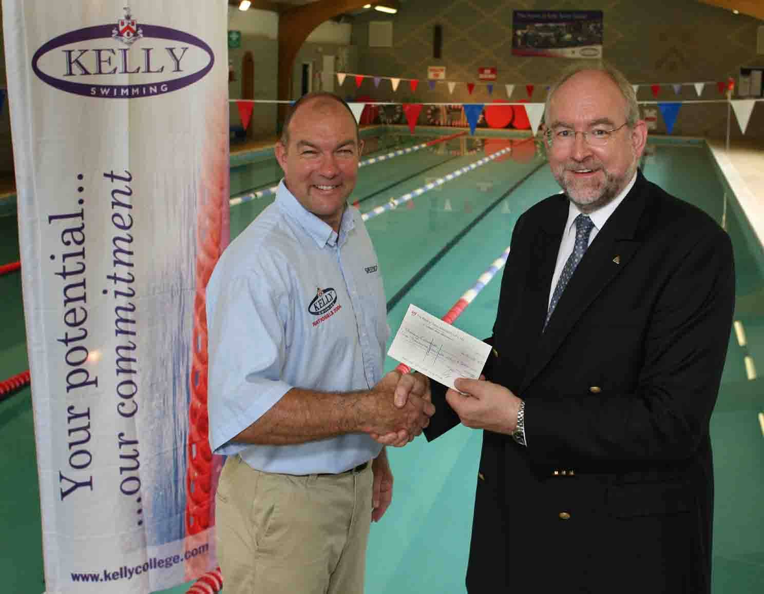 Robin Brew, Director of Swimming at Kelly College, accepts the cheque from Adam Rawicz, Managing Director of Lambda